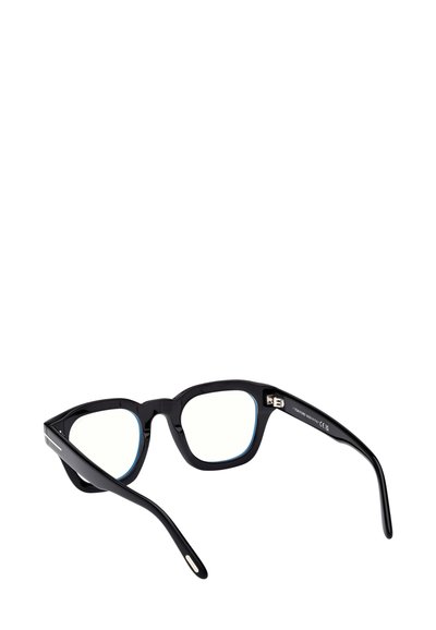 Occhiali con montatura rettangolare nera e lenti sfumate di blu. Presentano aste spesse, finitura lucida e sottili dettagli in metallo sulle cerniere.