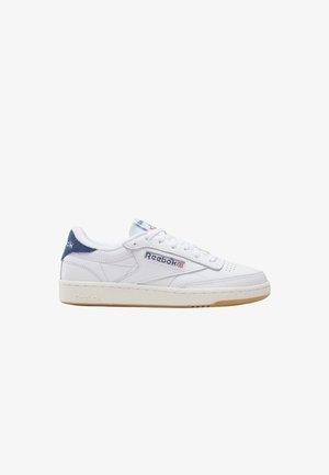 Sneaker Reebok in pelle bianca con linguetta sul tallone blu navy, etichetta laterale con logo e suola in gomma beige, vista dal lato esterno.