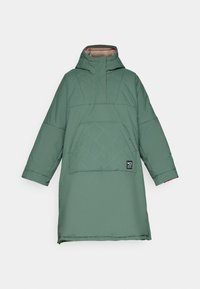 Abrigo pullover aislante verde con cuello alto, patrón de rombos diagonal, gran bolsillo frontal y una etiqueta en la parte inferior izquierda.