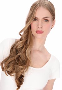 Lang, golvend lichtbruin haar dat over de schouder valt. Gladde, lichte huid; draagt een nauwsluitende witte geribde top met een ronde halslijn.