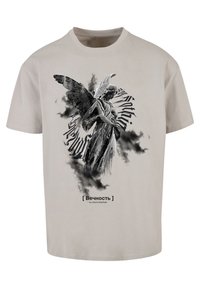 Light gray cotton t-shirt featuring a black and white angel graphic with swirling text and a cloud-like background. Text: "[ Вечность ]".