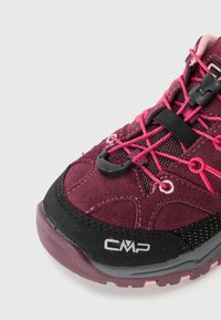 Zapato de senderismo violeta con acentos en negro y rosa, parte superior de ante texturizado, paneles de malla y un sistema de cordones seguro. Logo de CMP en el lateral.