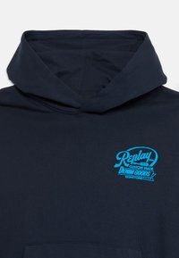 Tamnoplavi dukserica s kapuljačom, s prednjim džepom i svijetloplavim logotipom "Replay Custom Made Denim Goods" na prsima.