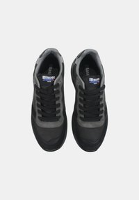Sneakers neri e grigi realizzati con una combinazione di materiali in suede e mesh. Presentano lacci neri, un colletto imbottito e dettagli del logo sulla linguetta.