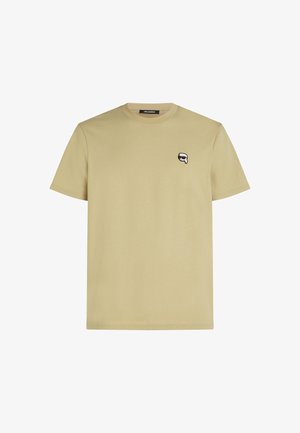 T-shirt léger en kaki à manches courtes en coton doux. Avec un petit logo noir et blanc sur la poitrine gauche. Design simple à col rond.