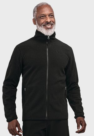 Schwarze Zip-Jacke mit einem strukturierten Muster, hohem Kragen und Seitentaschen. Hergestellt aus einem weichen Material, mit einem subtilen Logo auf der Brust.