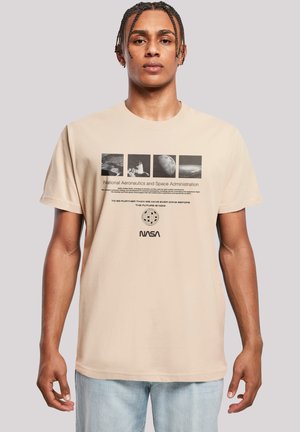 Beige cotton t-shirt featuring NASA graphics, including photographs and text, with a round neck and short sleeves.
