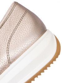 Detailní záběr na patu béžové texturované kožené tenisky s dvojitým šitím, bílou stélkou a hnědou gumovou podrážkou s vroubkovaným vzorem.