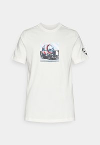 Hvid bomulds t-shirt med et grafisk tryk af et futuristisk køretøj med et cirkulært design, præsenteret mod en lys blå geometrisk baggrund.