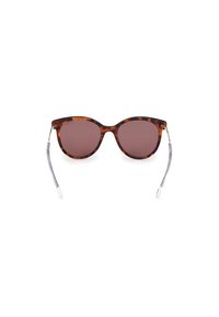 Gafas de sol carey con lentes redondeados y brazos transparentes. Los lentes de color marrón proporcionan un estilo vintage, complementado con elegantes acentos metálicos.