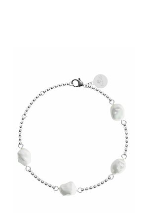 Bracelet en perles argentées avec quatre perles blanches irrégulières, fermé par un fermoir de type homard et une petite étiquette.