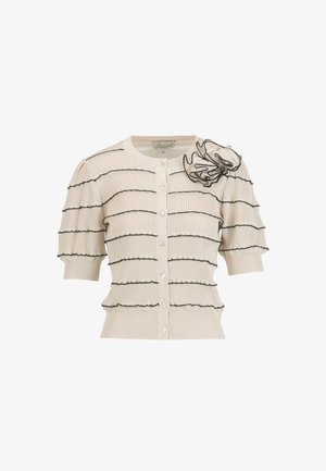 Krémový krátky pletený kardigán s krátkymi rukávmi, so šikmými čiernymi volánovými pruhmi, perlovými gombíkmi a veľkou čiernou kontúrovanou volánovou kvetinou na ramene.