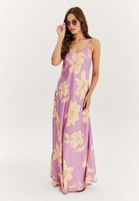 Maxi šaty z lehké fialové látky s velkými broskvovými květinovými vzory, s tenkými ramínky a splývavým střihem.