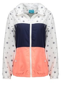 Farveopdelt jakke med en hvid overdel præget af anker mønstre, en navy midtersektion og en koralfarvet undersektion. Indeholder en hætte og lynlås.