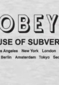 T-shirt grafica con testo in grassetto nero: "OBEY" in cima, seguito da "CAUSE OF SUBVERSION", con i nomi delle città elencati sotto in carattere più piccolo.