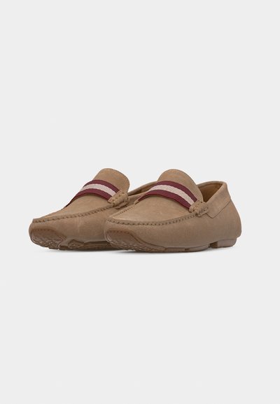 Paire de mocassins en daim beige avec des bandes en tissu rayé bordeaux et beige sur le dessus, présentant des détails cousus et des semelles en caoutchouc.