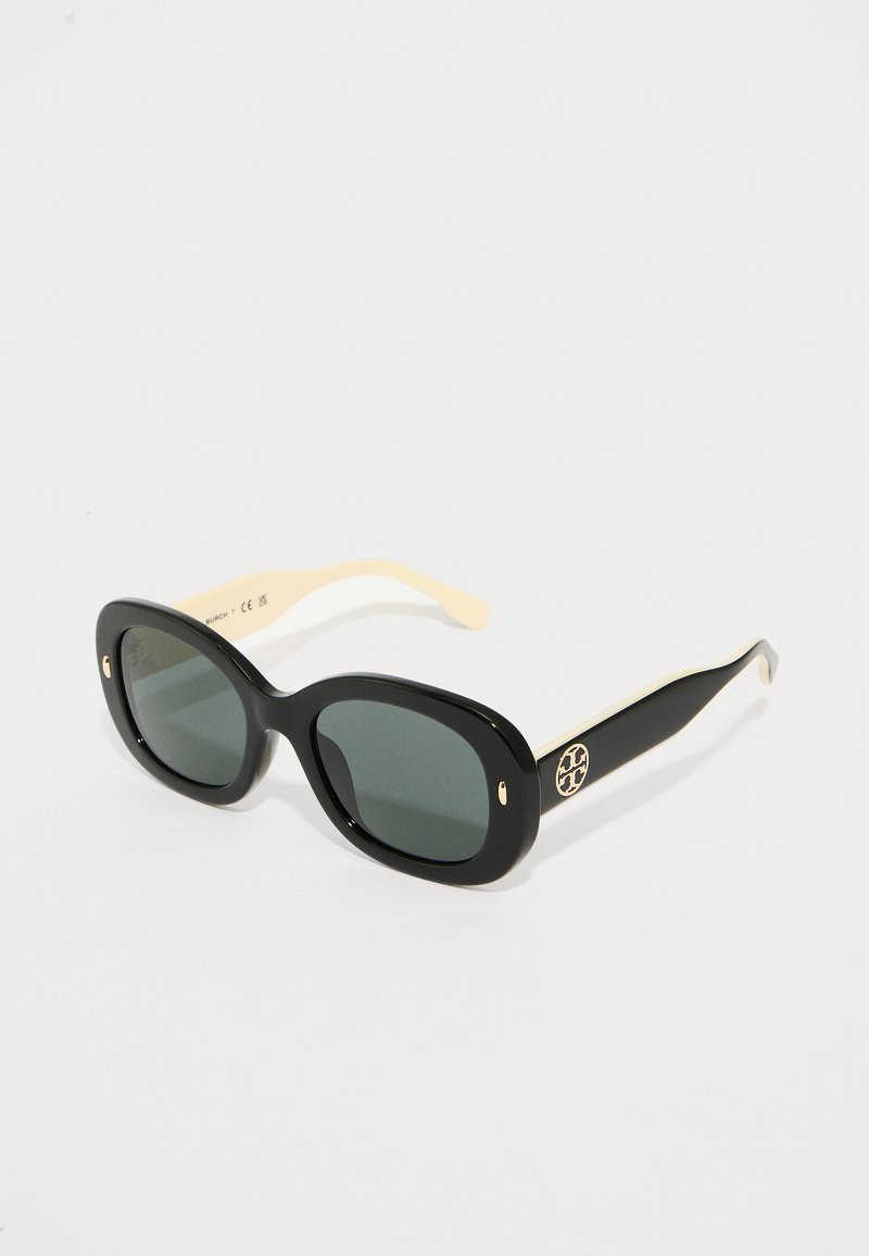 Μαύρα πλαστικά γυαλιά ηλίου με πράσινους φακούς και κρέμα λεπτομέρειες. Διαθέτουν χρυσό λογότυπο στη βραχίονα. Στρογγυλή, υπερμεγέθης σχεδίαση.