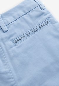 Hellblauer Stoff mit glatter Textur. Auf der Rückseite ist ein schwarzes Etikett angenäht, auf dem "BAKER BY TED BAKER" steht. Sauberes Design mit minimalen Akzenten.