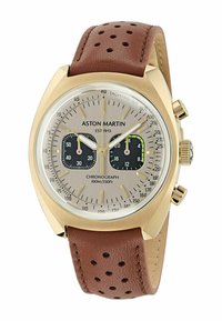 Kronografické hodinky Aston Martin so zlatým puzdrom, strieborným ciferníkom, čiernymi subciferníkmi, hnedým perforovaným koženým remienkom a tachymetrickou stupnicou.