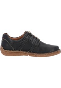 Zapato de cuero negro con costuras claras, punta redonda, diseño con cordones y suela texturizada marrón. Presenta un detalle en el panel lateral.