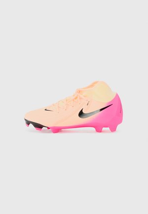 Nike voetbalschoenen in perzik en roze kleurverloop, met zwarte swoosh en accenten, voorzien van een gestructureerde bovenkant en gemolde noppen voor grip.