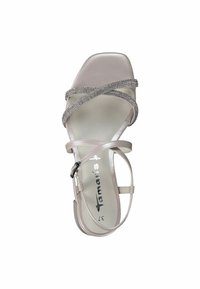 Beige korkokengät, joissa on ristiviillot koristeltuna timanteilla, neliön muotoinen kärki ja metallinen logo sisäpohjassa.