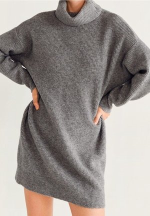 Abito in maglia grigia con colletto alto e arrotolato, vestibilità comoda, texture a coste, spalle cadenti e tasche laterali.
