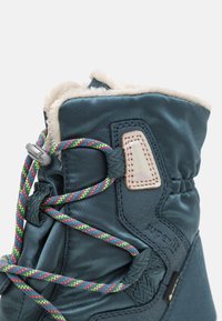 Kék textil csizma puha béléssel, színes fűzőkkel és díszítő folttal. Simma, vízálló külső anyag.