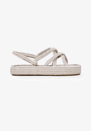 Sandalias de cuerda de color beige, con correas trenzadas y una suela texturizada. El diseño incluye patrones circulares a lo largo de los bordes.
