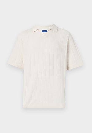 Lühikeste varrukatega V-kaelusega põimitud särk kreemjas valges värvitoonis, millel on vertikaalne ribatekstuur. Sukelduv krae ja lõdva lõike disain.