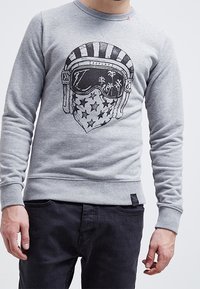 Sudadera gris con un diseño gráfico de un casco y una bufanda con estrellas, puños y dobladillo acanalados, confeccionada en una tela suave.
