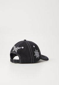 Căciulă de bază neagră cu broderie albă, având un design cu fluture și soare, curea ajustabilă în spate, construcție cu șase panouri.