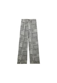 Trykt bukser med bred ben, der har et patchwork-design, hovedsageligt sort og hvid, med forskellige mønstre og en afslappet talje.