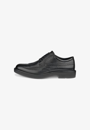 Schwarzer Leder-Wingtip-Brogue-Formalschuh mit perforierten Details und Schnürverschluss, gezeigt vor weißem Hintergrund.