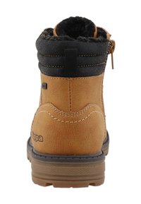 Brune ruskind ankelstøvle med sort polstret krave, sidezipper og gummisål med tekstureret mønster langs bunden.