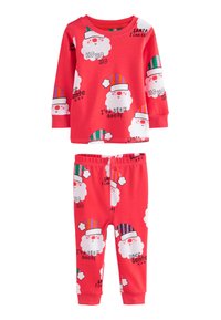 Ensemble de pyjama en coton rouge comprenant un haut à manches longues et un pantalon. Le motif présente des visages de Père Noël répétés avec des chapeaux colorés et du texte festif.