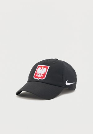 Gorra de béisbol negra Nike con el swoosh blanco en el lateral y parche rojo frontal con un emblema de águila coronada blanca.