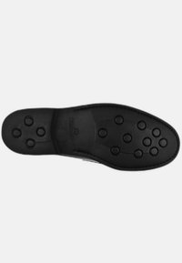 Suola di scarpa nera con una texture a motivo, caratterizzata da punti di presa circolari e bordi lisci, progettata per trazione e durata.
