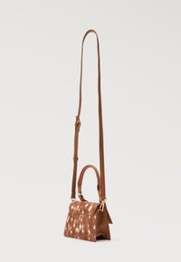 Μικρή καφέ τσάντα χιαστί με κοντή λαβή, ρυθμιζόμενο μακρύ λουρί και διακριτικό λευκό πουά σχέδιο στην μπροστινή πτέρυγα.