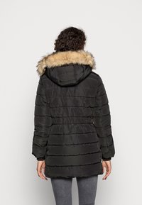 Černá nadýchaná parka s kapucí z umělé kožešiny, s páskem v pase a horizontálním prošíváním, navržená pro teplo a pohodlí.