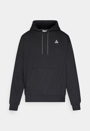 Fekete kapucnis pulóver puha anyagból, kenguru zsebbel, bordázott mandzsettákkal és a mellkason egy kis fehér logóval.