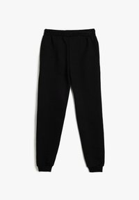 Pantalones de chándal negros fabricados con una tela texturada, con una cintura elástica y tobillos ajustados, que presentan un corte suave y relajado.
