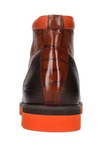 Bota de cuero texturizado marrón con un patrón de cocodrilo, panel lateral negro y suela de goma naranja. Cuenta con un cuello naranja en contraste.