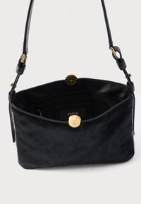 Geantă de mână din piele neagră cu textură moale, închidere magnetică rotundă aurie și o singură curea de umăr. Interior captusit afișează eticheta brandului.