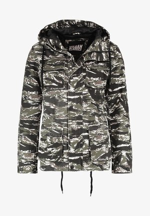 Roheline ja valge kamuflaažimustriga jakk, millel on kapuuts, mitu esipakki ja reguleeritavad tõmblukud ääres.