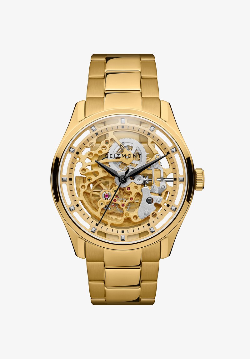 Gullfarget skjelettarmbåndsur med synlige gir, svarte time- og minuttvisere, gullfarget metallrem, og merkevarenavnet Seizmont på urskiven.