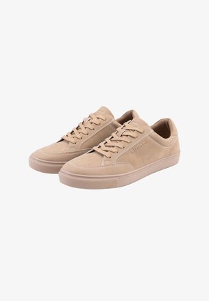 Paire de baskets basses en daim beige avec lacets assortis et semelles en caoutchouc sur fond blanc.