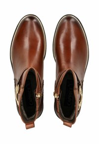 Botas de tobillo de cuero marrón con un acabado suave, punta redondeada y detalles en hardware dorado. Incluyen paneles laterales texturizados y tiradores.