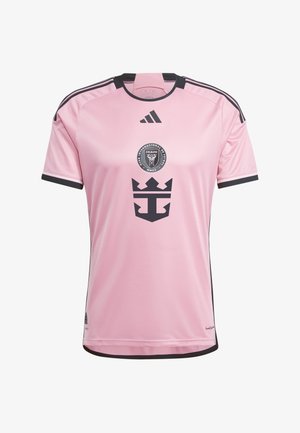 Camiseta de fútbol de manga corta rosa con detalles en negro, que presenta un logo circular del club y un emblema oscuro en el frente, confeccionada con material transpirable.