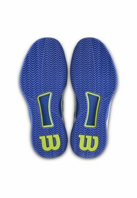 Suelas de zapatos de goma azul con una textura ondulada, que presentan un acento verde y un detalle de marca. Bordes suaves y forma redondeada.